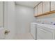 Bright laundry room with a side-by-side washer and dryer and upper cabinets for storage, all freshly painted at 15 Richland Acres Ct, Henderson, NV 89074