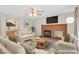 Staged living room with a brick fireplace, sofa, coffee table, and mounted television at 15 Richland Acres Ct, Henderson, NV 89074