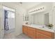 Bathroom with double vanity, large mirror, and a separate toilet/shower area with a tub at 1712 Warrenville St, Las Vegas, NV 89117