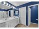 Bathroom with blue walls, dual sinks, a shower, and a separate toilet room at 1836 Soto Ln, North Las Vegas, NV 89032