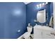 Charming powder room featuring blue accent wall, white vanity, and oval mirror at 1836 Soto Ln, North Las Vegas, NV 89032