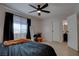 Relaxing bedroom with a ceiling fan, plush bedding, and an open doorway to a bathroom at 1847 Avacado Ct, Henderson, NV 89014
