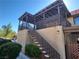 Low-angle view of home featuring an open-air patio on the second floor with stairs and a landscaped yard at 1847 Avacado Ct, Henderson, NV 89014