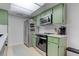 View of the kitchen featuring green cabinets, stainless steel appliances, and light wood flooring at 1847 Avacado Ct, Henderson, NV 89014