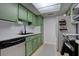Kitchen with green cabinets, stainless steel appliances, white countertops, and a grey accent rug at 1847 Avacado Ct, Henderson, NV 89014