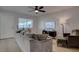 Spacious living room with a large gray sofa, ceiling fan, and access to the entrance at 1847 Avacado Ct, Henderson, NV 89014