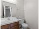 Clean bathroom featuring a wood vanity, white countertops, and a functional toilet, providing a tidy and simple space at 2042 Waverly Cir, Henderson, NV 89014