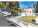 Charming two-story stucco home with a two-car garage, mature landscaping, and a well-maintained lawn on a sunny day at 2042 Waverly Cir, Henderson, NV 89014