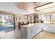 Bright kitchen features white cabinets, tile floors, peninsula, and dining area with backyard access at 2042 Waverly Cir, Henderson, NV 89014