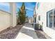 Narrow side yard featuring rock ground cover and the side of the home with an air conditioning unit at 2042 Waverly Cir, Henderson, NV 89014