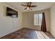 Bedroom with tile floors, television, ceiling fan, and window with curtain at 2120 Ramrod Ave # 415, Henderson, NV 89014