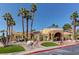 Exterior of a clubhouse surrounded by palm trees and desert landscaping at 2120 Ramrod Ave # 415, Henderson, NV 89014
