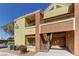Exterior of tan and brown condo building featuring balconies and stairs at 2120 Ramrod Ave # 415, Henderson, NV 89014