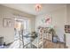 Cozy dining area with a glass table, white chairs, and a sliding glass door to the outdoor space at 2609 Orchard Meadows Ave, Henderson, NV 89074