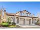 Attractive stucco townhome with a tile roof, arched entryways, and attached two-car garages at 2609 Orchard Meadows Ave, Henderson, NV 89074