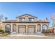 Inviting two-story townhome featuring dual garages and landscaped front yards under a bright blue sky at 2609 Orchard Meadows Ave, Henderson, NV 89074