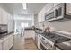 Well-lit kitchen with stainless steel appliances, black countertops, and white cabinets at 2609 Orchard Meadows Ave, Henderson, NV 89074