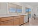 Bright kitchen with stainless steel sink, wood cabinets, tile floors, and a sliding glass door at 2920 Foxtail Creek Ave, Henderson, NV 89052