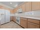 Well-lit kitchen with white appliances, light wood cabinets, tile floors, and white countertops at 2920 Foxtail Creek Ave, Henderson, NV 89052