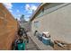 A fenced yard has a stone walkway along the side of the home, and storage for bins and a bike at 2963 Greendale St, Las Vegas, NV 89121