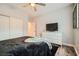 Bedroom with closet and door, featuring a dresser with television, hardwood floors, and decor at 3 Chatmoss Rd, Henderson, NV 89052