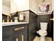 Elegant powder room featuring stylish dark wainscoting, gold fixtures, and modern design elements at 3111 Bel Air Dr # 5F, Las Vegas, NV 89109