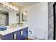 Modern bathroom featuring a blue vanity, gold fixtures, and a walk-in shower with marble tile at 3111 Bel Air Dr # 5F, Las Vegas, NV 89109