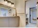 Well-lit bathroom with a vanity, decorative mirror, and tiled shower at 3111 Bel Air Dr # 5F, Las Vegas, NV 89109