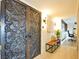 Unique carved double doors lead into a hallway with a seating bench and view of the office at 3111 Bel Air Dr # 5F, Las Vegas, NV 89109