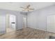 Bright bedroom with wood floors leads to private bathroom and closet; neutral tones and ceiling fan at 3197 Castle Canyon Ave, Henderson, NV 89052