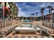 Stylish pool area with modern furniture, palm trees, and building view on sunny day at 353 E Bonneville Ave # 905, Las Vegas, NV 89101