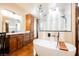 This bright bathroom features a soaking tub, glass shower, skylight, and custom vanity at 479 Apogee, Mesquite, NV 89027