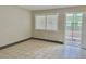 A sunlit living room with neutral walls, tiled flooring, and an exit door at 520 S 13Th St # D17, Las Vegas, NV 89101