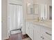 Well-lit bathroom featuring a modern vanity with quartz countertop and a shower with a white curtain at 580 Kenerly St, Henderson, NV 89015