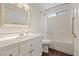 Bright bathroom with white vanity, quartz countertop, tiled shower, and updated fixtures at 580 Kenerly St, Henderson, NV 89015