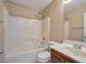 Bright bathroom featuring a tub with white tile surround and wood vanity with sink at 5963 W Dewey Dr, Las Vegas, NV 89118