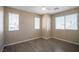 Bright bedroom featuring three windows, neutral walls, and wood look floors at 5963 W Dewey Dr, Las Vegas, NV 89118