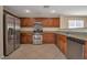 Well-equipped kitchen with stainless steel appliances, granite counters, and wooden cabinetry at 5963 W Dewey Dr, Las Vegas, NV 89118