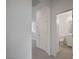 Hallway view to bright bathroom with a quartz vanity, and adjacent rooms in a neutral-toned home at 6261 Dolosonte St, Las Vegas, NV 89113