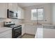Close-up of kitchen featuring stainless steel appliances, white countertops and cabinetry at 6261 Dolosonte St, Las Vegas, NV 89113
