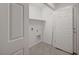 Bright laundry room featuring tile flooring, crisp white walls, shelving and washer/dryer hookups at 6261 Dolosonte St, Las Vegas, NV 89113
