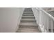 Carpeted stairway with white banister for a simple, clean look at 6261 Dolosonte St, Las Vegas, NV 89113