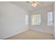 Bright, carpeted bedroom with neutral walls, a ceiling fan, and three large windows at 7337 Tealwood St, Las Vegas, NV 89131