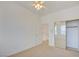 Bright bedroom with carpet, ceiling fan, and mirrored closet door, adjacent to staircase at 7337 Tealwood St, Las Vegas, NV 89131