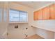 Practical laundry room with window, storage cabinets, and utility connections at 7337 Tealwood St, Las Vegas, NV 89131