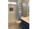 Bright bathroom featuring a shower-tub combo with elegant marble-style tiles and a blue-toned vanity at 7728 Barbican Ct, Las Vegas, NV 89147