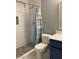 Bathroom with stylish shower-tub featuring marble-style tiles and blue vanity with modern sink and faucet at 7728 Barbican Ct, Las Vegas, NV 89147