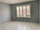 Serene bedroom features a window with plantation shutters and tile flooring at 7728 Barbican Ct, Las Vegas, NV 89147