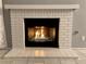Inviting living room featuring a painted white brick fireplace with glass rocks at 7728 Barbican Ct, Las Vegas, NV 89147