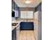 Cozy kitchen showcasing white appliances, blue cabinets, and a window at 7728 Barbican Ct, Las Vegas, NV 89147
